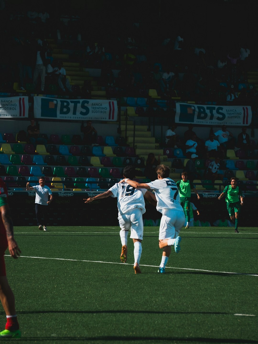 Football players celebrating a goal in a stadium